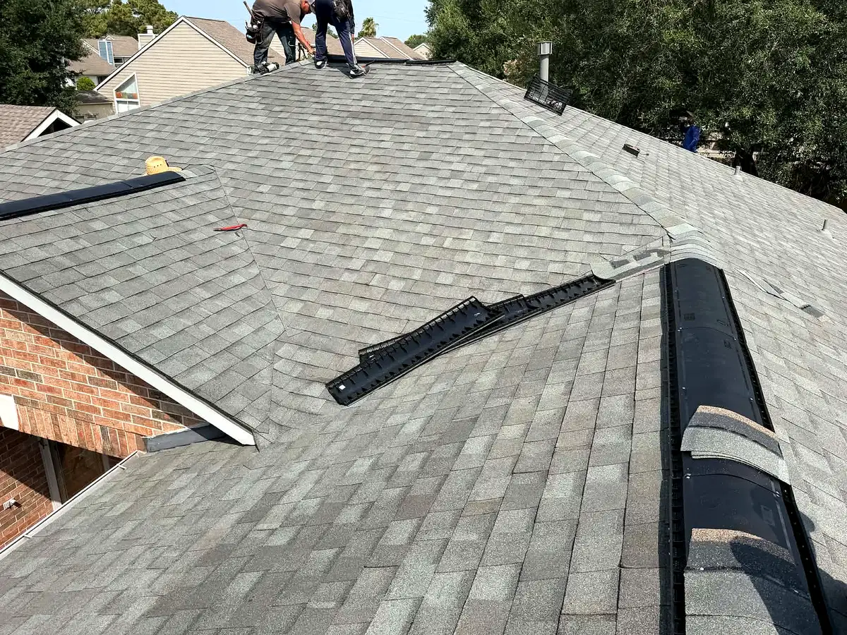 Roofing work in progress along a residential roof ridge